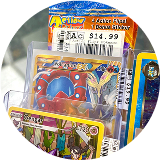 Close-up of assorted Pokémon trading cards in protective sleeves displayed for sale, including rare and holographic cards with price stickers.