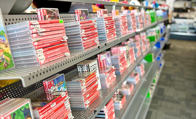 Shelf rows filled with Nintendo Switch game cases arranged in a video game store, with bright red spines lined up in neat rows.